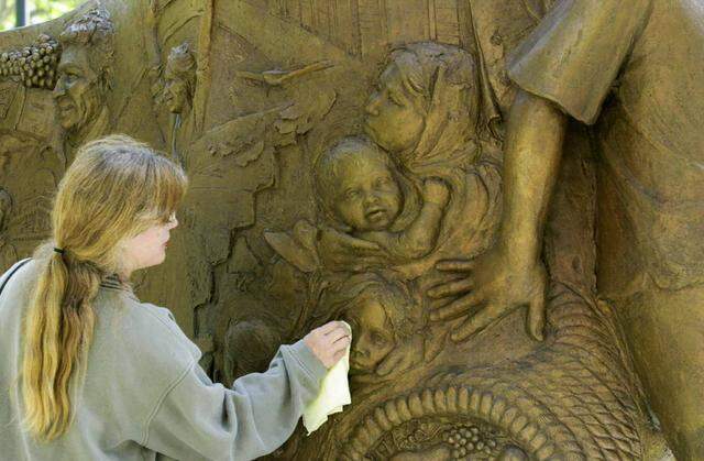 Lisa Reinertson, of Davis, applies wax in 2001 to the bronze sculpture that she created for the Cesar E. Chavez Plaza in downtown Sacramento. The statue depicts the Delano to Sacramento march in 1966, which Reinertson attended as a child.